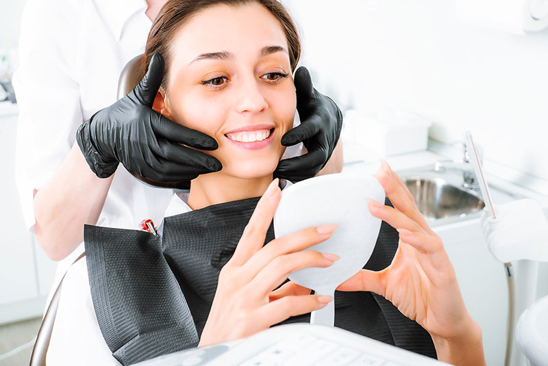 dentist showing woman her teeth