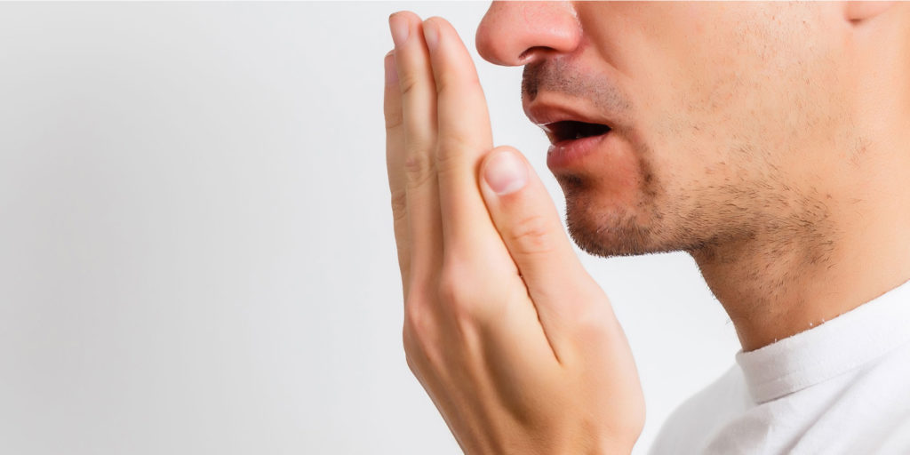 man checking his breath side view