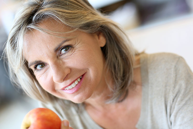 woman dentures holding apple